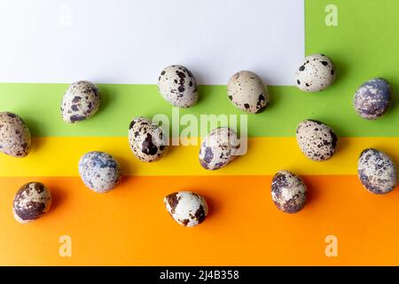 petits œufs de caille à pois dispersés sur un tissu beige et bouquet de fleurs de gitsophila bleu séchées. Banque D'Images