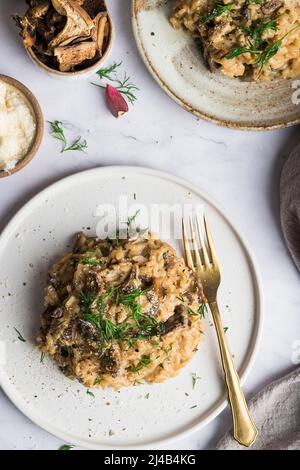 Risotto aux champignons porcini sur une petite assiette et recouvert d'aneth frais Banque D'Images