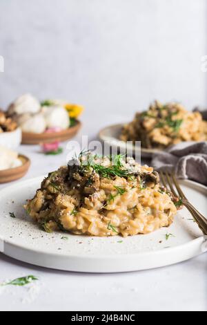 Risotto aux champignons porcini sur une petite assiette et recouvert d'aneth frais Banque D'Images