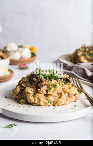 Risotto aux champignons porcini sur une petite assiette et recouvert d'aneth frais Banque D'Images