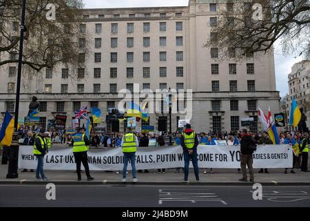 Londres, Royaume-Uni. 13th avril 2022. Les partisans ukrainiens tiennent une bannière exprimant leur opinion au cours de la manifestation. Des partisans ukrainiens se réunissent quotidiennement dans le centre de Londres pour protester contre l'invasion russe de l'Ukraine depuis le 24th février 2022. Ils continuent de demander à l'OTAN de fermer l'espace aérien au-dessus de l'Ukraine pour empêcher la Russie de bombarder le pays et envoyer des armes pour soutenir l'armée ukrainienne. Crédit : SOPA Images Limited/Alamy Live News Banque D'Images