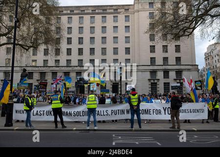 Londres, Royaume-Uni. 13th avril 2022. Les partisans ukrainiens tiennent une bannière exprimant leur opinion au cours de la manifestation. Des partisans ukrainiens se réunissent quotidiennement dans le centre de Londres pour protester contre l'invasion russe de l'Ukraine depuis le 24th février 2022. Ils continuent de demander à l'OTAN de fermer l'espace aérien au-dessus de l'Ukraine pour empêcher la Russie de bombarder le pays et envoyer des armes pour soutenir l'armée ukrainienne. (Photo de Hesther ng/SOPA Images/Sipa USA) crédit: SIPA USA/Alay Live News Banque D'Images