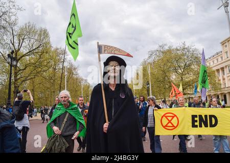 Londres, Royaume-Uni. 13th avril 2022. Un manifestant portant un costume de sinistre marche dans le Mall pendant la manifestation de la rébellion d'extinction. Des centaines de manifestants ont défilé dans le centre de Londres, exigeant que le gouvernement agisse sur la crise écologique et climatique. Crédit : SOPA Images Limited/Alamy Live News Banque D'Images