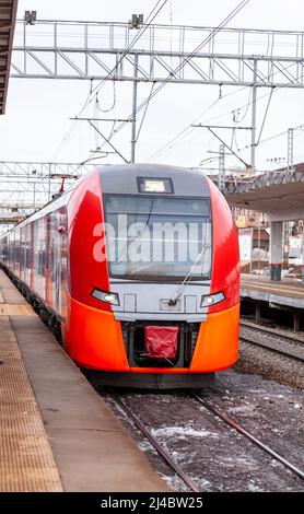 Le train à grande vitesse moderne se déplace rapidement le long de la plate-forme. Les gens attendent le train à la gare, les transports en commun. Banque D'Images