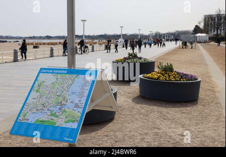 13 avril 2022, Schleswig-Holstein, Travemünde: Les gens marchent le long de la promenade de la plage sur la mer Baltique à Travemünde. Après une pause de deux ans due à la pandémie, la station balnéaire de Travemünde veut recommencer la saison avec son programme traditionnel 'Ostermünde'. Photo: Christian Charisius/dpa Banque D'Images