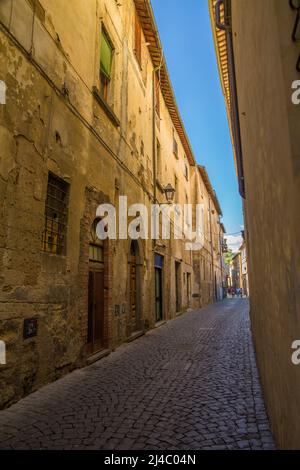 Les touristes descendent une rue pavée étroite à Orvieto, une ville colline dans la région Toscane de l'Italie Banque D'Images