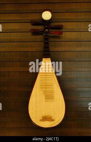 Une pipa accrochée à un mur. C'est un instrument de musique chinois à quatre cordes. Banque D'Images