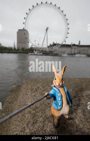 USAGE ÉDITORIAL SEULEMENT photo du dossier datée du 31/05/16 d'une sculpture miniature du personnage de Beatrix Potter Peter Rabbit prenant un selfie près du London Eye à Londres, comme le premier livre de Beatrix Potter le Tale de Peter Rabbit a inspiré une initiative de jardinage marquant 120 ans du classique très aimé des enfants. Banque D'Images