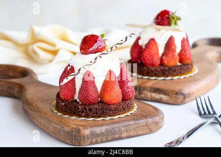 Gâteau aux fraises. Gâteau rempli de crème au milieu, entouré de fraises, sur fond blanc. Produits de boulangerie. Gros plan Banque D'Images