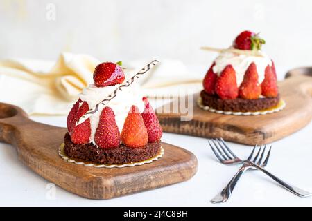 Gâteau aux fraises. Gâteau rempli de crème au milieu, entouré de fraises, sur fond blanc. Produits de boulangerie. Gros plan Banque D'Images