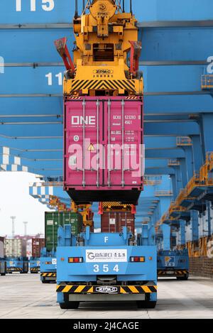 QINGDAO, CHINE - le 13 AVRIL 2022 - des véhicules guidés automatiques transportent des marchandises au quai entièrement automatisé du port de Qingdao, dans la province de Shandong en Chine orientale Banque D'Images