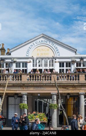 Les gens sur le balcon extérieur du Punch & Judy pub se socialisent et apprécient des rafraîchissements lors d'une chaude journée ensoleillée. Covent Garden, Londres, Angleterre, Royaume-Uni. Banque D'Images