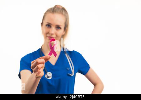 Campagne de protection contre le sida. Professionnelle de la santé travailleuse dans un uniforme bleu tenant le ruban rouge avec ses doigts. Prise de vue moyenne en studio. Photo de haute qualité Banque D'Images