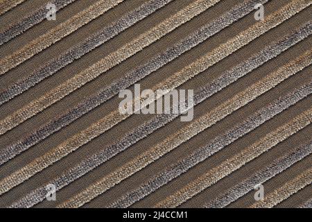 La texture d'un tissu en velours de coton beige naturel à rayures claires, située en diagonale. Les crêtes de la velours côtelé sur la diagonale Banque D'Images