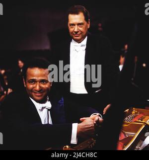 Andre Watts, amerikanischer Pianist und Rafael Frühbeck de Burgos, auch Rafael Frühbeck, spanischer Dirigent, deutscher Herkunft, gemeinsamer Auftritt beim Wohltätigkeitskonzert zugunsten der Deutschen Fernsehlotterie, Datum auf dem Bilgesd: 1985, circa. Andre Watts, pianiste américain, et Rafael Fruehbeck de Burgos, également Rafael Fruehbeck, chef d'orchestre espagnol d'origine allemande, se présentant ensemble à un concert caritatif au profit de la Loterie de télévision allemande, photographiée vers 1985, date estimée. Banque D'Images