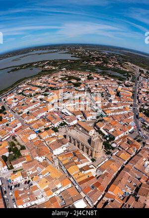 Tir de drone, photo de drone de Saintes-Maries-de-la-Mer avec la vieille ville, le port, l'église notre Dame et les champs de sel en arrière-plan, département Banque D'Images