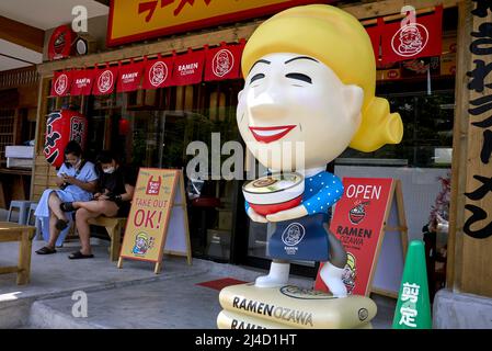 Extérieur du restaurant japonais avec grande statue colorée d'une serveuse Banque D'Images