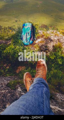 Sac à dos et jambes de randonnée dans les chaussures de sport de la jeune femme se reposant dans une randonnée en montagne dans la vallée, vie active saine en plein air loisirs Banque D'Images