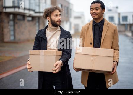 Couple gay marchant ensemble avec des colis à l'extérieur Banque D'Images