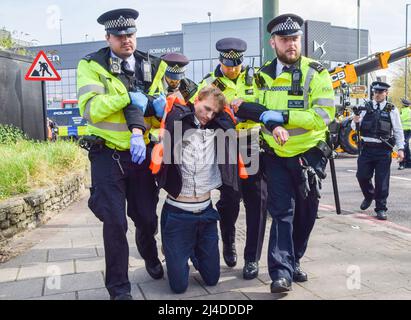 Londres, Royaume-Uni, 14th avril 2022. Les policiers retirent et arrêtent un manifestant. Les activistes Just Stop Oil se sont collés au sommet d'un pétrolier et ont bloqué la circulation au rond-point de Chiswick dans l'ouest de Londres pour protester contre les combustibles fossiles. Le groupe a pour objectif de perturber le flux de pétrole dans la capitale. Credit: Vuk Valcic/Alamy Live News Banque D'Images