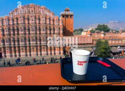 Petit déjeuner sur le toit donnant sur le Hawa Mahal et le Jaipur. Hawa Mahal - le temple des vents, l'attraction principale de l'Inde. Tasse de café Banque D'Images