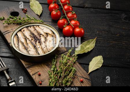 Ouvrir une boîte de sardines, sur fond de table en bois noir, avec un espace de copie pour le texte Banque D'Images