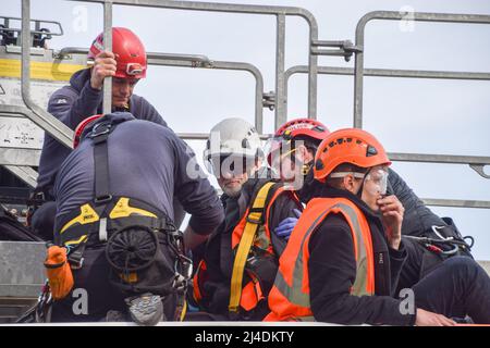 Londres, Angleterre, Royaume-Uni. 14th avril 2022. Les policiers se préparent à enlever un manifestant sur le dessus du pétrolier. Les activistes Just Stop Oil se sont collés au sommet d'un pétrolier et ont bloqué la circulation au rond-point de Chiswick dans l'ouest de Londres pour protester contre les combustibles fossiles. Le groupe a pour objectif de perturber le flux de pétrole dans la capitale. (Credit image: © Vuk Valcic/ZUMA Press Wire) Credit: ZUMA Press, Inc./Alamy Live News Banque D'Images