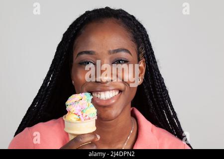 Jeune femme noire appréciant un cône de glace Banque D'Images