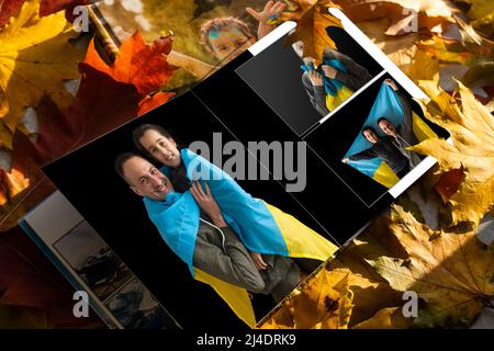 Archives photos de famille enregistrées dans un livre photo aux couleurs vives ; souvenirs d'été éclatants placés dans le livre photo. Famille avec drapeau de l'ukraine Banque D'Images