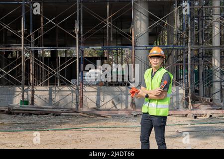 Architecte, ingénieur ou entrepreneur masculin réussi sur un chantier où les armes sont croisées. Jeune homme d'affaires ingénieur de chantier de construction. Banque D'Images