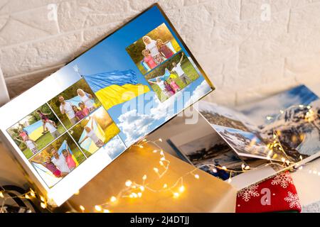 Archives photos de famille enregistrées dans un livre photo aux couleurs vives ; souvenirs d'été éclatants placés dans le livre photo. Famille avec drapeau de l'ukraine Banque D'Images