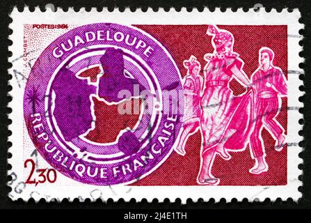 FRANCE - VERS 1984 : un timbre imprimé en France montre la Guadeloupe, la carte et les danseuses de l'Ouest indien, vers 1984 Banque D'Images