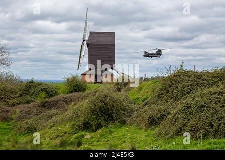 Un hélicoptère Chinook CH-47 de la Royal Air Force passe bas et près du moulin à vent de Brill, Buckinghamshire, au Royaume-Uni, lors d'une journée de printemps avec des nuages gris bas. Banque D'Images