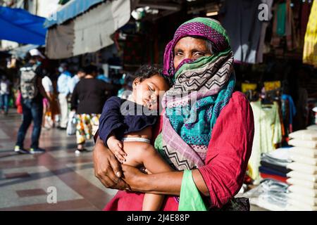 La vieille femme mendière indienne avec son bébé engendra les aumône dans la rue de New Delhi, en Inde Banque D'Images