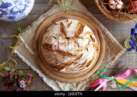 Pain de levain maison avec œufs de Pâques, fleurs de printemps et fouet tchèque appelé pomlazka Banque D'Images