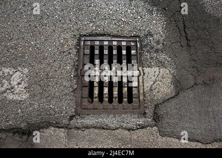 Grille en fonte sur le drain. Grille en fonte sur le canal de drainage. Grille de vidange d'eau de tempête sur un trottoir en pierre. Banque D'Images