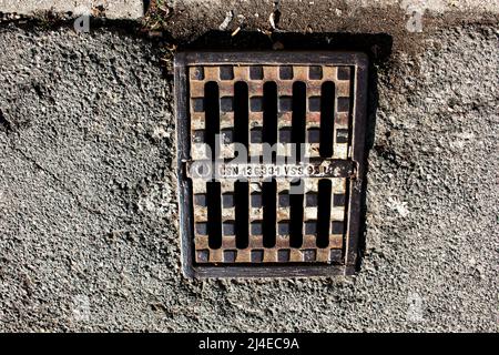 Nitra, Slovaquie - 07.15.2021: Grille en fonte sur le drain. Grille en fonte sur le canal de drainage. Grille d'évacuation d'eau de pluie sur chaussée en pierre. Banque D'Images