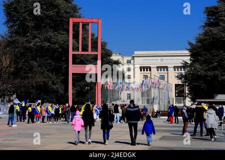 GENÈVE, SUISSE, 3 MARS 2022. Promenade en famille jusqu'au monument Broken chair en police de tête des Nations Unies et drapeaux à la place des Nations Banque D'Images