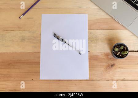 Papier vierge A4 posé sur un bureau en bois avec fournitures Banque D'Images