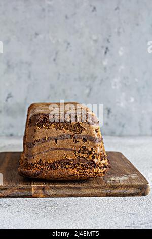 Gâteau marbré au chocolat (biscuit) zèbre avec glaçage au chocolat sur une planche en bois sur fond gris. Dessert maison. Banque D'Images