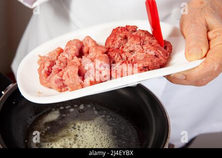 Préparation de bœuf haché avec la sauce traditionnelle colombienne hogao ou criollo (salsa criolla) à base d'oignon, de tomate, de poivrons et de coriandre Banque D'Images