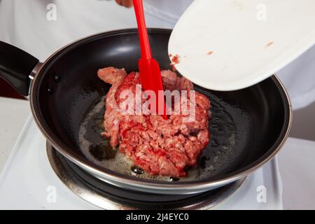 Préparation de bœuf haché avec la sauce traditionnelle colombienne hogao ou criollo (salsa criolla) à base d'oignon, de tomate, de poivrons et de coriandre Banque D'Images