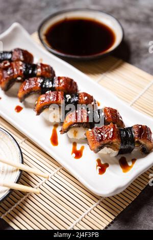 Sushis à l'anguille disposés dans une assiette et prêts à servir. Banque D'Images