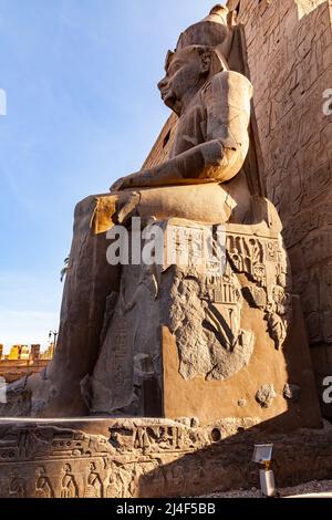 Vue du matin à angle bas de la statue du Pharaon Ramses II devant le pylône du complexe du Temple de Louxor à Louxor, en Égypte. Banque D'Images