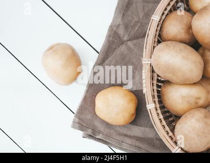 pommes de terre fraîches sur une table de cuisine, pommes de terre dans un panier. légumes frais cultivés dans le jardin. menu végétarien, vue de dessus Banque D'Images