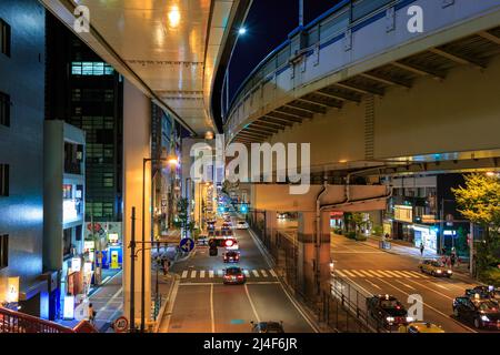 Vue en hauteur des voitures sur une route large sous des voies surélevées la nuit Banque D'Images