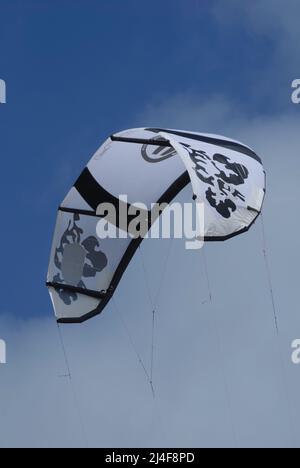 Le kite surf noir et blanc s'oppose à un ciel bleu Banque D'Images