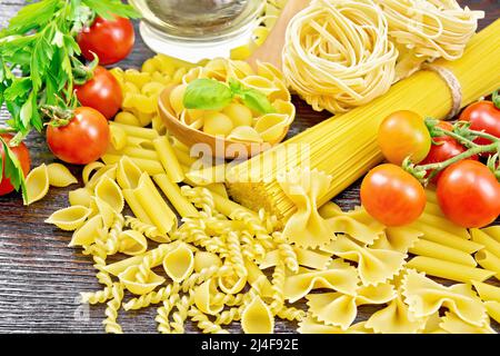 Pâtes à coque en cuillère, truquage de tuyaux, spaghetti, tagliatelles, fusilli, penne, farfalle, conquila, trenette, rotini, tomates, ail, huile dans un decan Banque D'Images