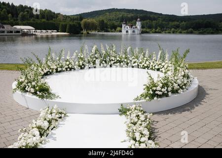 Cérémonie de mariage. Très beau et élégant lieu de mariage, décoré avec diverses fleurs fraîches, debout près du lac. Jour de mariage. Banque D'Images