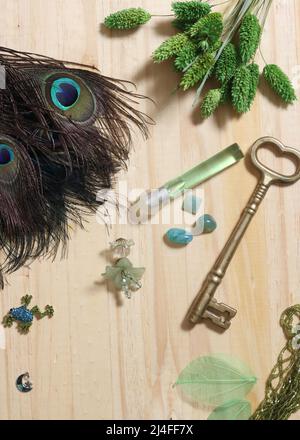 Plumes de paon avec perles vertes et brocher de papillons de cuivre et de vert sur table en bois Banque D'Images